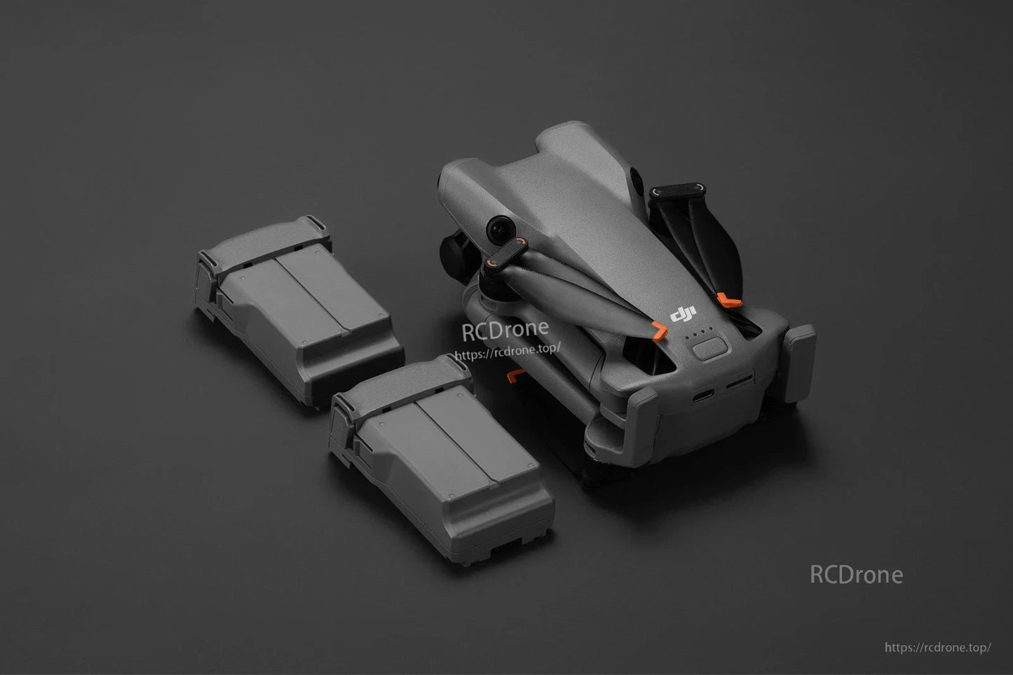 DJI Mini 5 Pro Intelligent Flight Battery packs beside a folded DJI Mini drone on a dark background