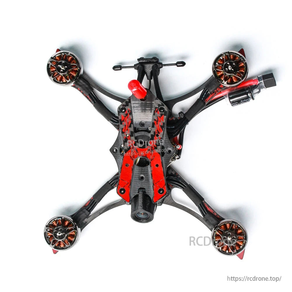 Bottom view of quadcopter showing FPV camera mount, motors, and power lead routing