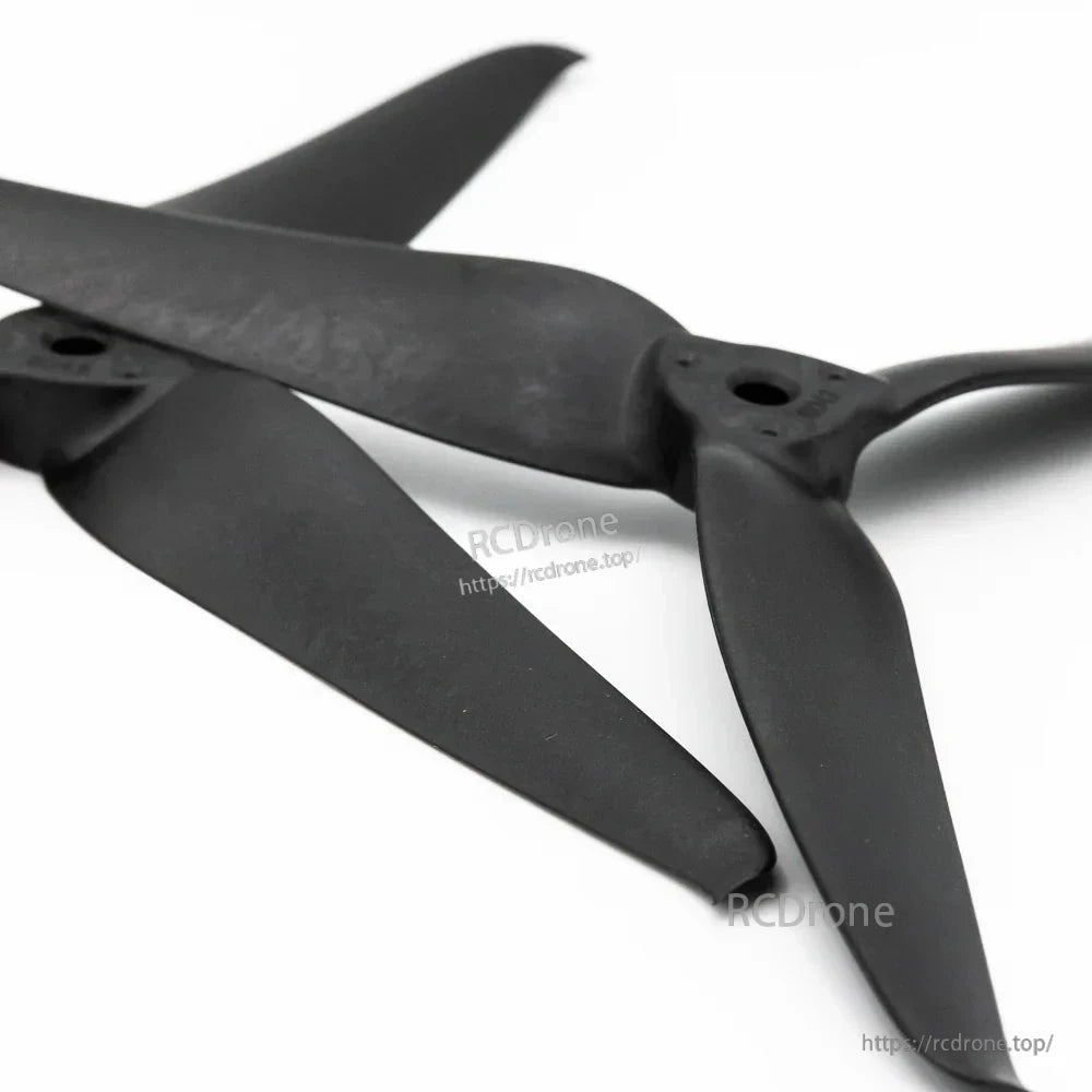 Angled view of two black 8043-3 tri-blade FPV drone props overlapping, showing blade shape and hub