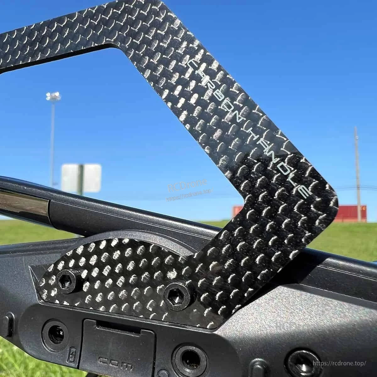 Close-up of Futaba carbon fiber handle mounting points and engraved branding on transmitter top plate
