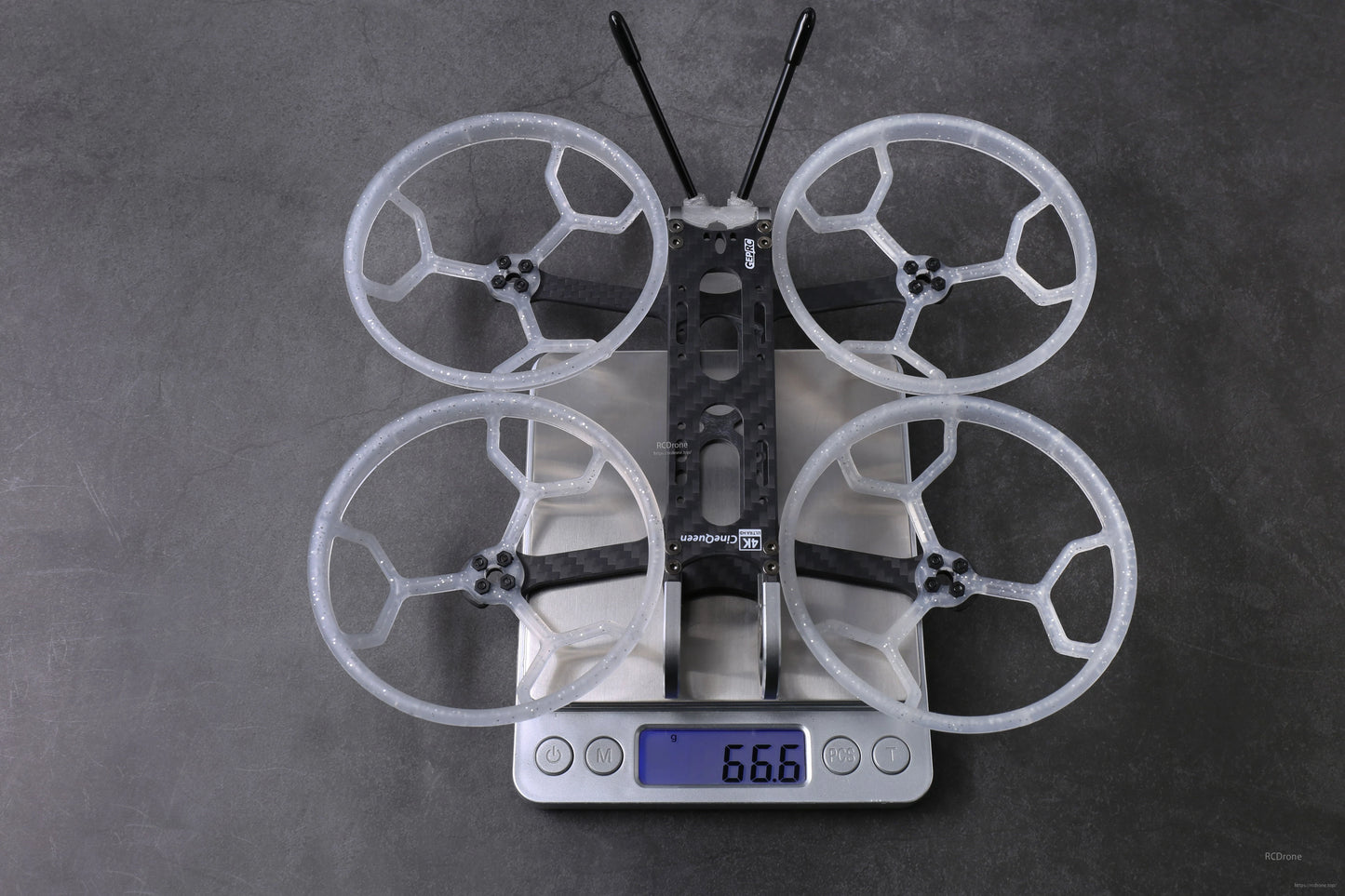 GEPRC GEP-CQ 3-inch FPV frame with four prop guards and antennas on a digital scale reading 66.6 g