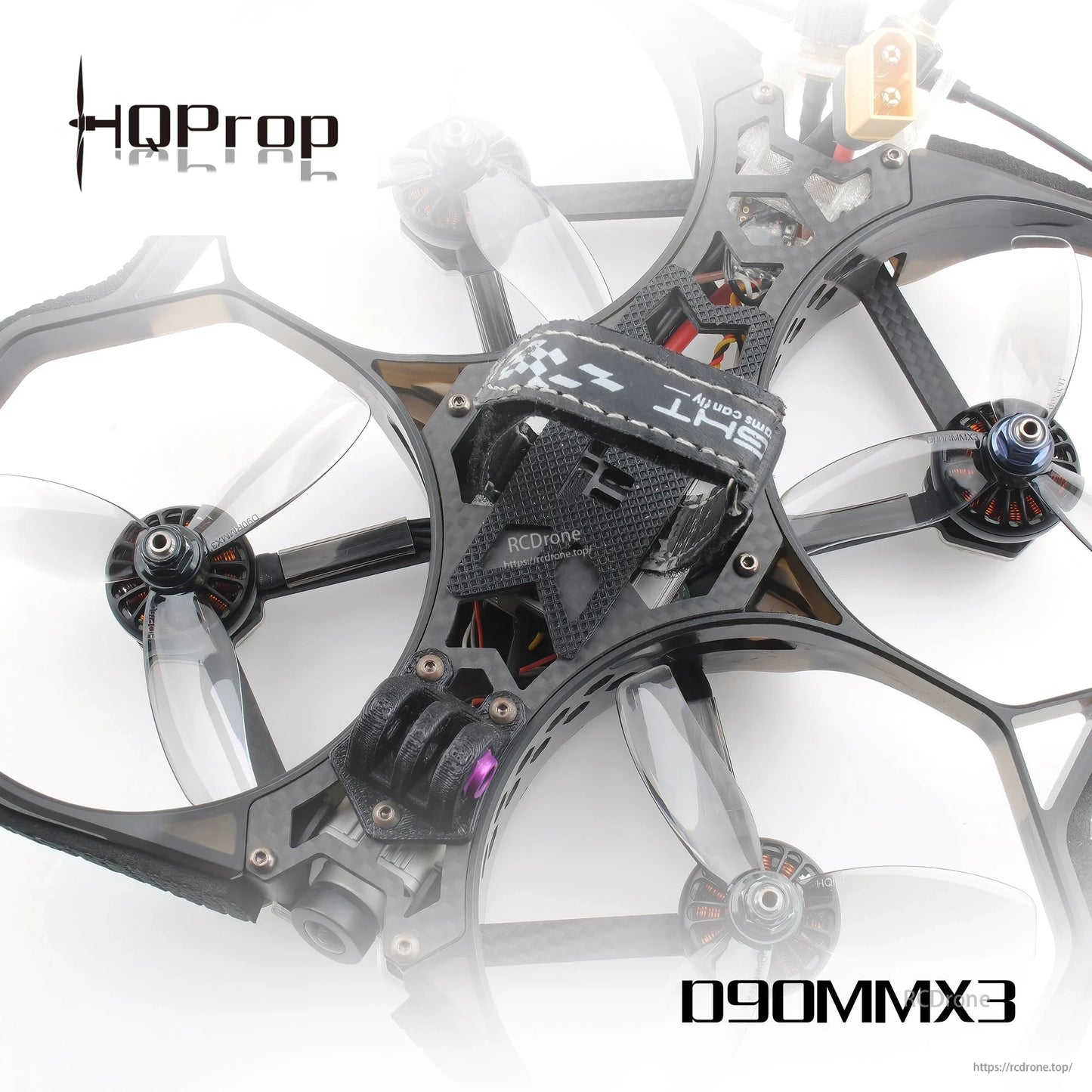 Translucent grey 3-blade props mounted on a ducted cinewhoop quadcopter, top angled view