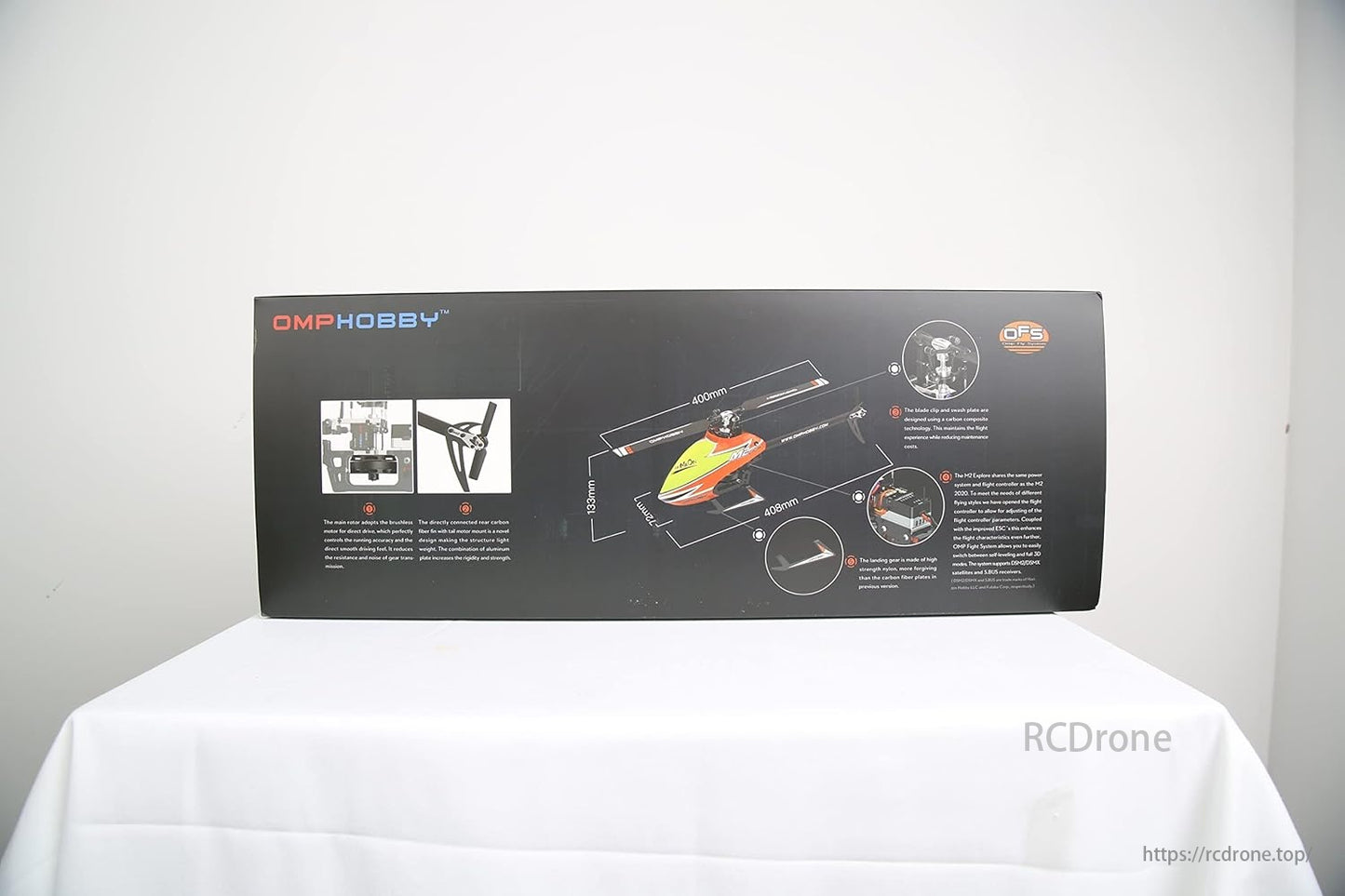 OMPHOBBY M2 Explore RC Helicopter, OMPHOBBY's packaging details a remote-controlled aircraft with brushless motor rotors, carbon fiber for rigidity, and durable landing gear.