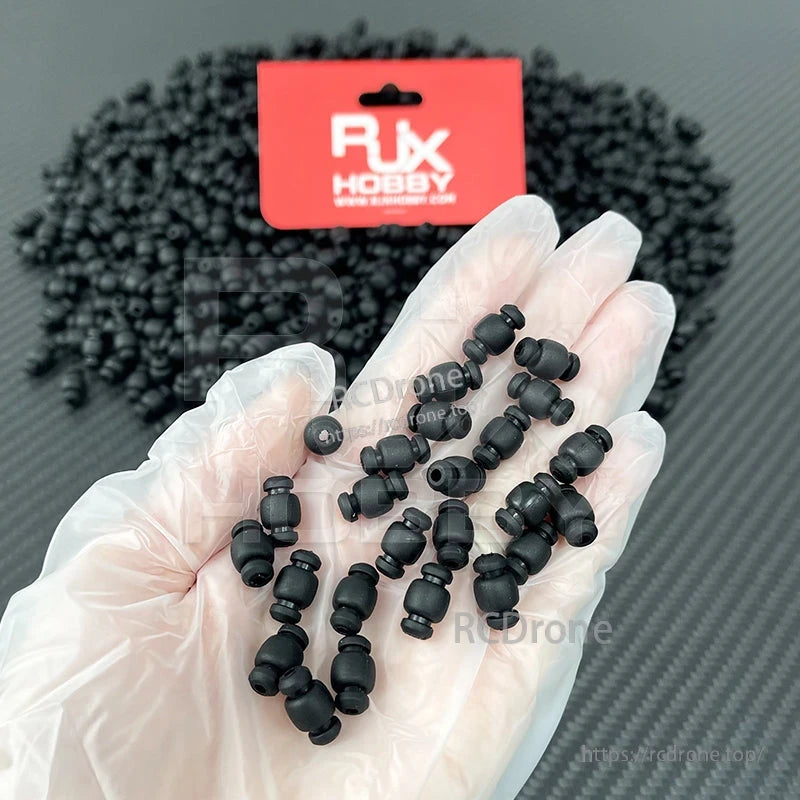 RJX Main Control Damper Shock Absorbing Ball, Hand holding RJX Hobby black rubber damper shock absorbing balls for RC main control mounting