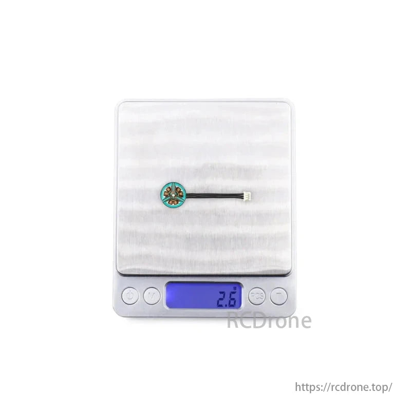 Micro brushless FPV motor on scale, displaying weight of 2.6 grams.