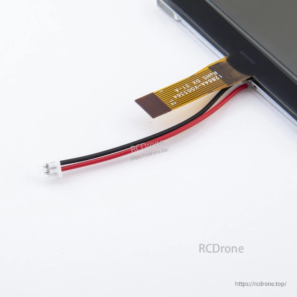 Close-up of TX12 LCD ribbon flex connector and red/black power lead with small white plug