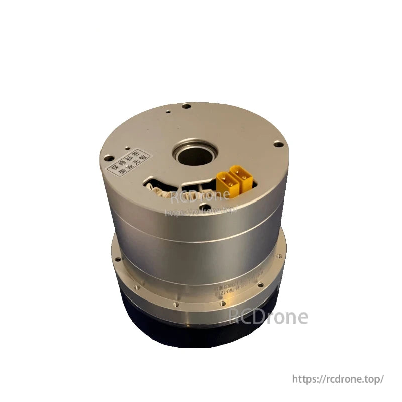 Three-quarter view highlighting connector bay cutout, yellow power terminals, and center bore on top face