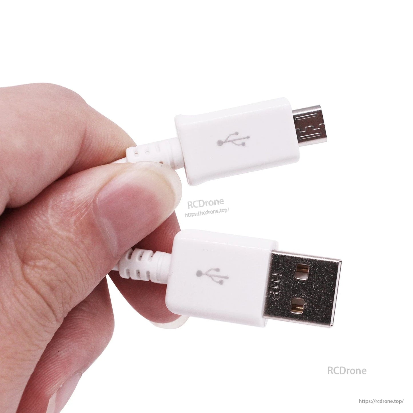 Hand holding white USB-A and micro USB connectors, close-up of plugs and strain relief