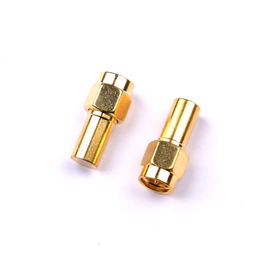Gold SMA/RP-SMA male coaxial termination dummy load plugs with hex nut body, two pieces on white background