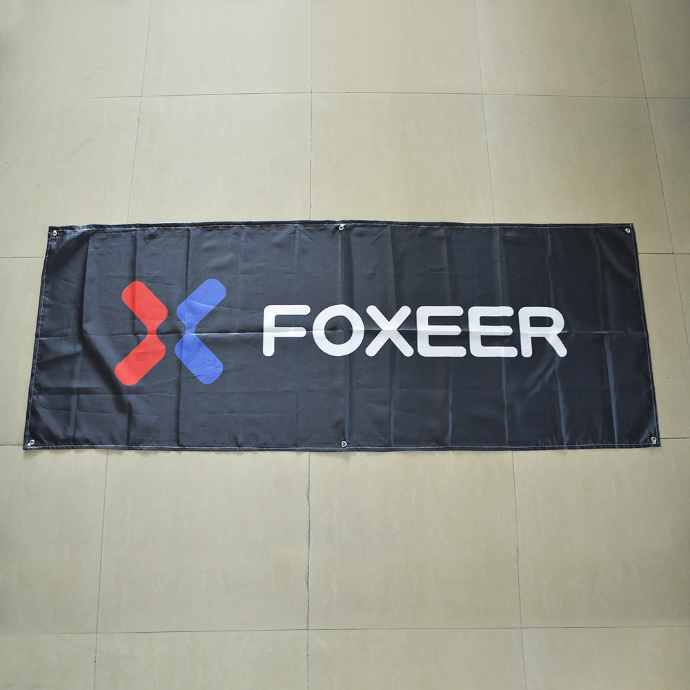 Black FOXEER fabric banner with large white logo and brass grommets along the edges for easy mounting