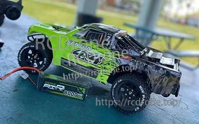 2-pack Ovonic 3S 8000mAh 50C 11.1V LiPo batteries powering an RC short course truck on a bench