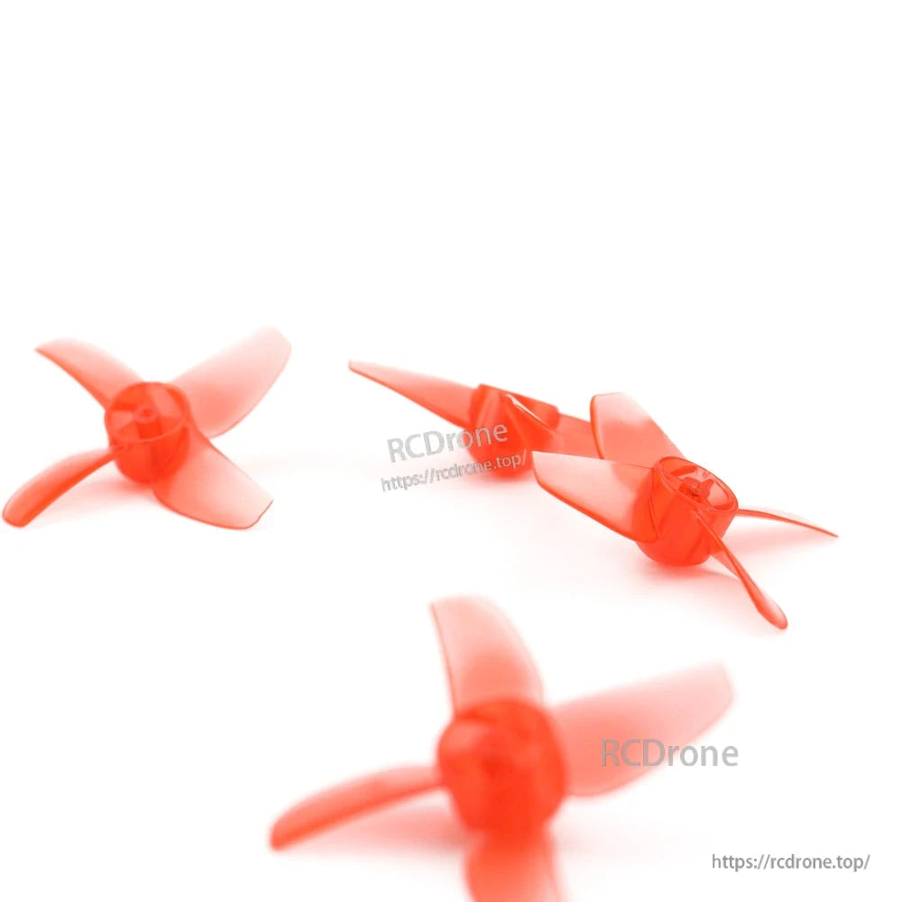 Close-up depth-of-field shot of red 4-blade FPV drone propellers highlighting hub detail