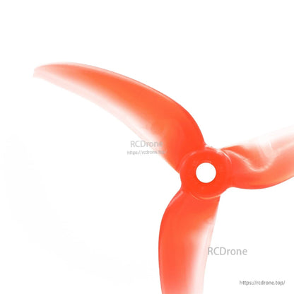 Close-up of propeller hub and center mounting hole on translucent red 3-blade FPV prop