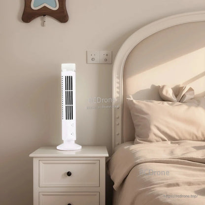 White tower fan with LED light glowing on nightstand next to bed in bright bedroom