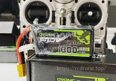 Ovonic 2-Pack 100C 6S 22.2V 1300mAh LiPo battery close-up with XT60 lead on workbench