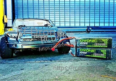 Pair of Ovonic 3S 11.1V 5500mAh 50C LiPo packs next to an RC drift-style car