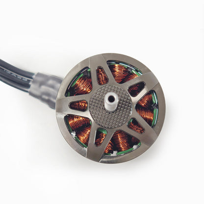 Top view of motor windings and rotor hub with centered shaft opening and attached wire lead