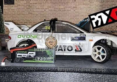 Ovonic 2S hard case LiPo battery pack next to a 1/10-scale RC drift car for size reference