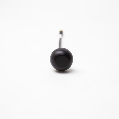 Front view of black mushroom antenna dome on coax lead, centered on white background