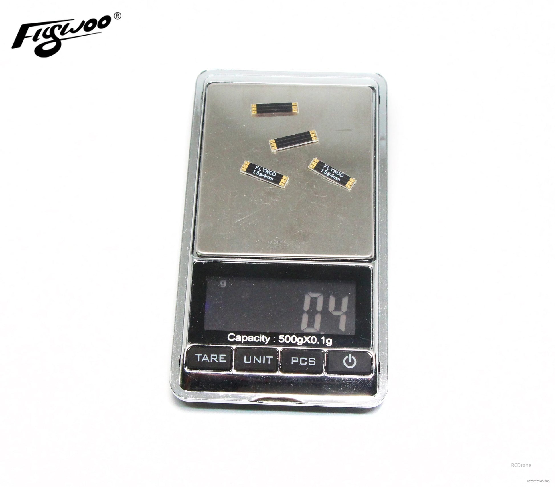 Four Flywoo frame arm boards labeled 15x4mm with gold pads, placed on a digital gram scale