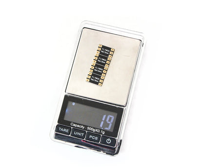 FLYWOO FPV drone frame arm board on a digital scale showing 1.9 g weight, with labeled solder pads