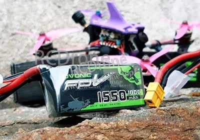 Ovonic FPV 6S 1550mAh 100C LiPo Battery with XT60 plug next to FPV quadcopter