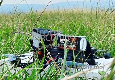 Close-up of Ovonic 120C 6S 1200mAh LiPo installed on a quadcopter frame in grass