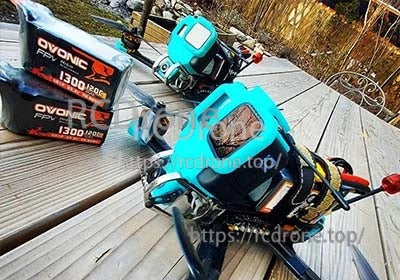 Ovonic 120C 6S 1300mAh 22.2V LiPo battery packs with an FPV racing quadcopter outdoors