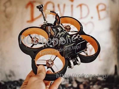 Compact FPV cinewhoop quad held in hand, sized for a 4S LiPo battery pack and freestyle flying