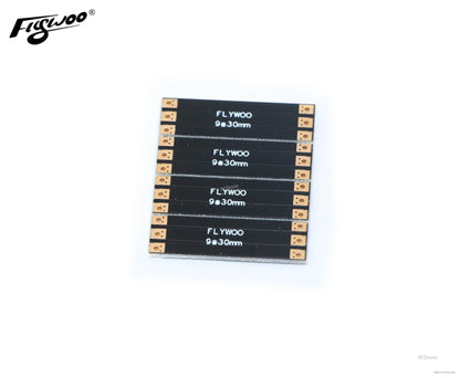 Four FLYWOO 9×30mm black frame arm boards with gold solder pads on each end for FPV drone builds