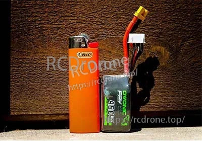 Ovonic 14.8V 4S 450mAh 80C LiPo battery pack with XT30 lead, size reference next to a lighter