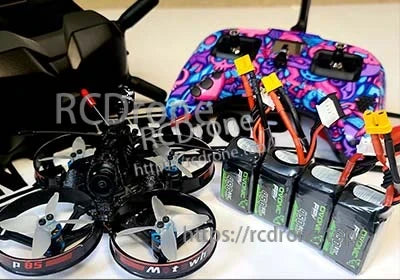 Ovonic 4pcs 14.8V 4S 450mAh 80C LiPo Battery set with XT30 connectors next to FPV transmitter and micro quads
