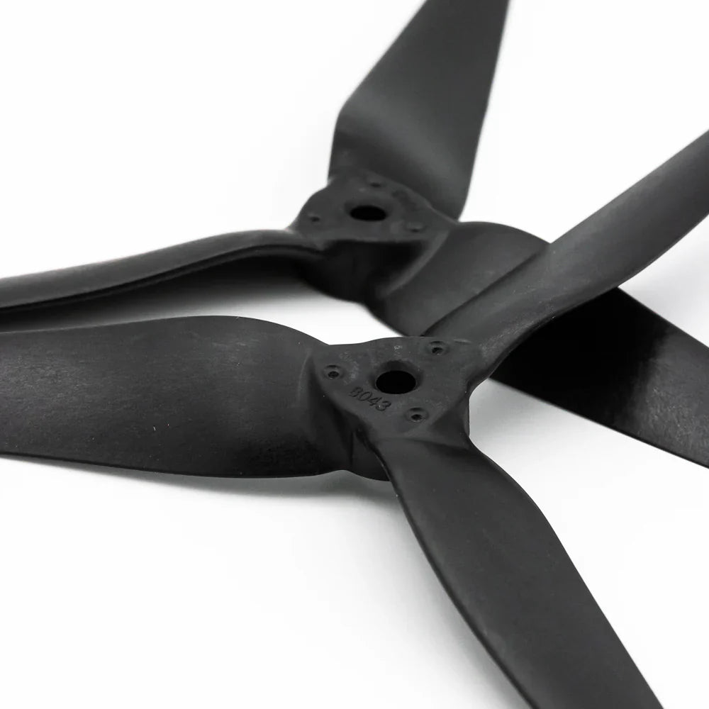 Close-up of 8043-3 propeller hubs showing center bore and mounting screw holes on black tri-blade props