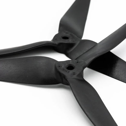 Close-up of 8043-3 propeller hubs showing center bore and mounting screw holes on black tri-blade props