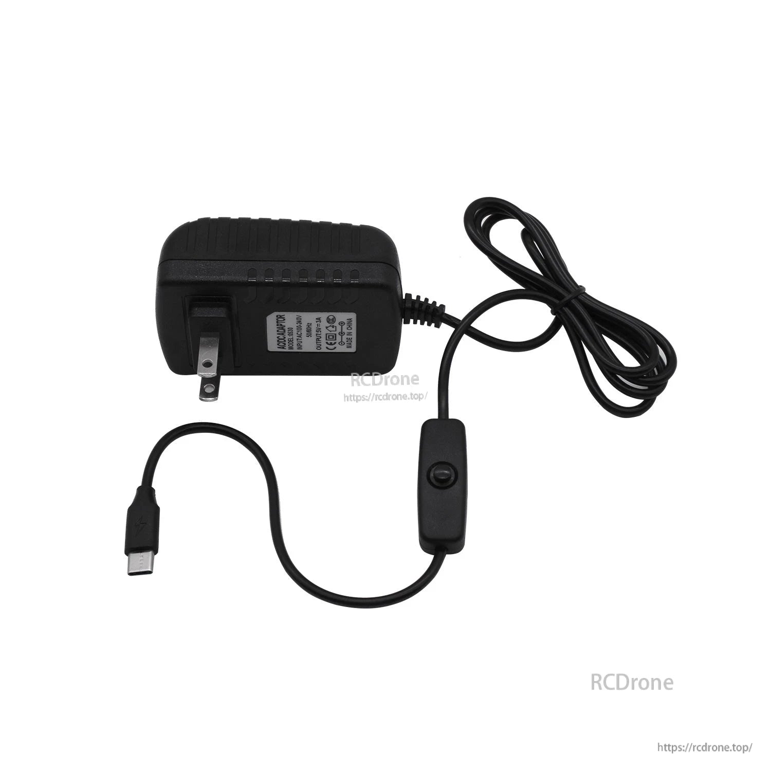 Side view of USB-C power adapter with inline switch and long cable laid out on white background