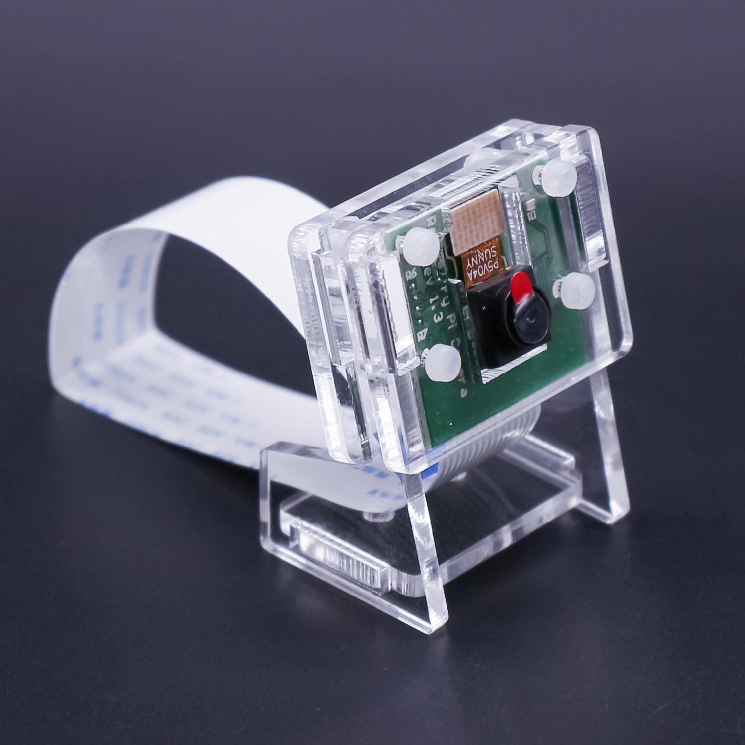 Clear acrylic camera case on display stand, angled view with CSI ribbon cable looped behind