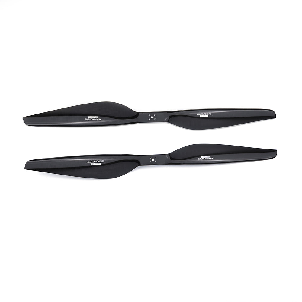 Pair of black carbon fiber drone propellers (CW and CCW) with mounting holes and branded hubs