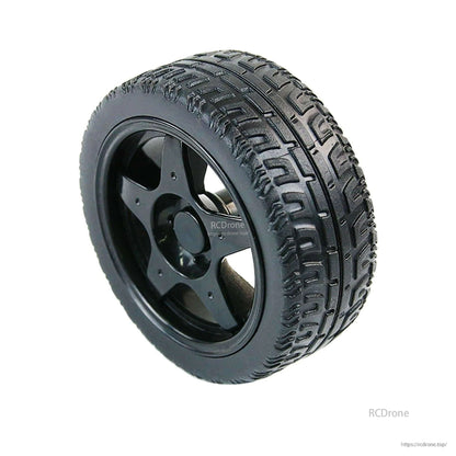 Single 65mm robot wheel with black ABS hub and patterned rubber tread, angled side view