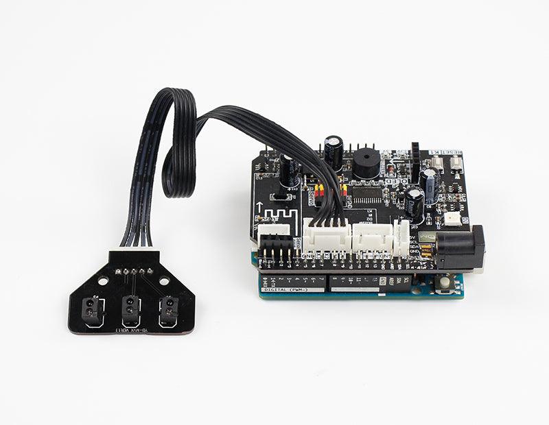 Tracking sensor module connected by ribbon cable to a controller board, showing wiring example