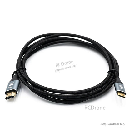 Coiled braided HDMI to mini HDMI cable on white background, connector ends visible with RCDRone watermark