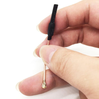Compact 70mm 5.8GHz FPV antenna shown in hand for size, with U.FL/IPEX connector on RG178 cable