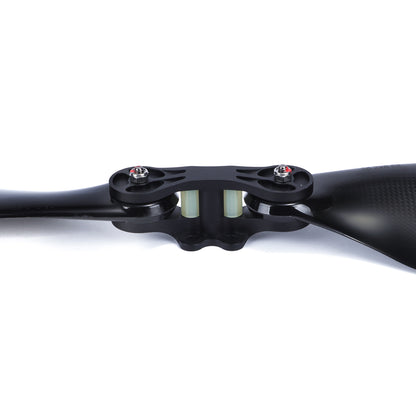 Close-up of a glossy carbon fiber folding propeller with central hub, bolts, and two black blades