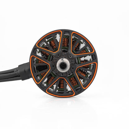 Top view of motor bell showing orange accents, copper windings, and three-wire lead exit