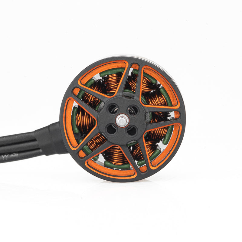 Top view of brushless motor showing orange rotor spokes, copper windings, and center shaft mount