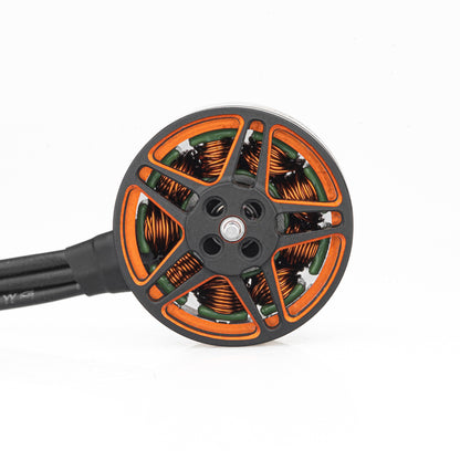 Top view of brushless motor showing orange rotor spokes, copper windings, and center shaft mount