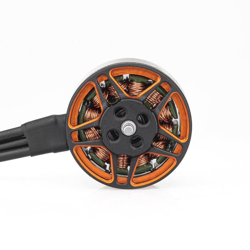 Top view of brushless motor rotor showing orange spokes, copper windings, and attached wires