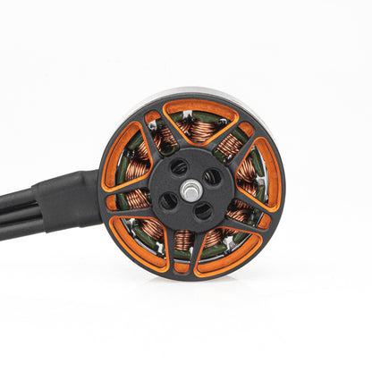 Top view of brushless motor rotor showing orange spokes, copper windings, and attached wires