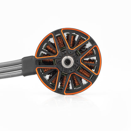 Top view of motor bell showing orange-accent spokes, visible copper windings, and attached power wires