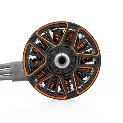 Top view of motor bell showing orange coil windings, ventilated spokes, and attached phase wires