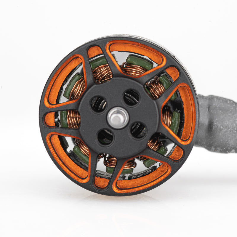 Top view of brushless motor showing orange spoke bell, mounting holes, and copper windings